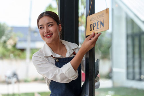 Shopkeeper putting up Open sign