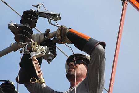 Trabajador de cables dando mantenimiento a una línea de transmisión