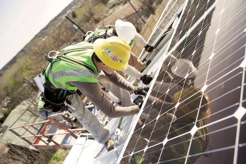 Workers installing rooftop solar panels