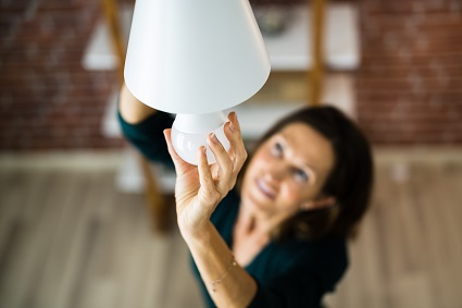 Woman safely changing an LED lightbulb