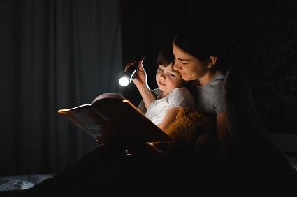 Family reading by flashlight during a power outage