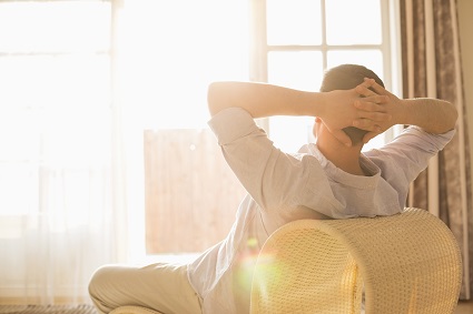 Man warming up with sunlight coming through his window